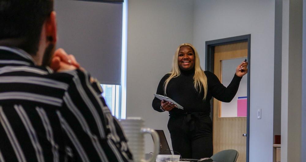 student standing and pointing at presentation